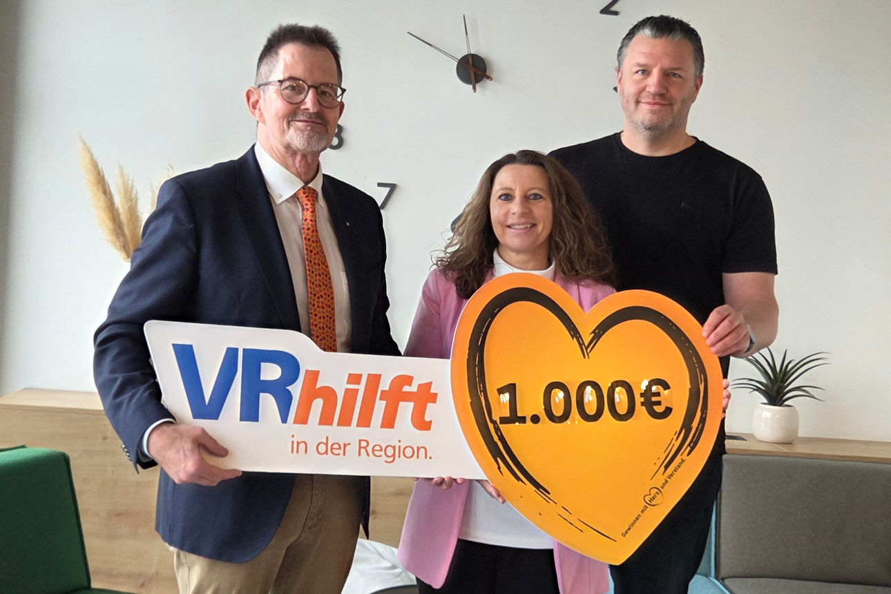 Auf dem Bild stehen der Spendenbotschafter der VR-Bank und zwei Mitglieder des Vereins. Sie halten ein Schild in Herzform mit der Spendenaufschrift in der Hand. 