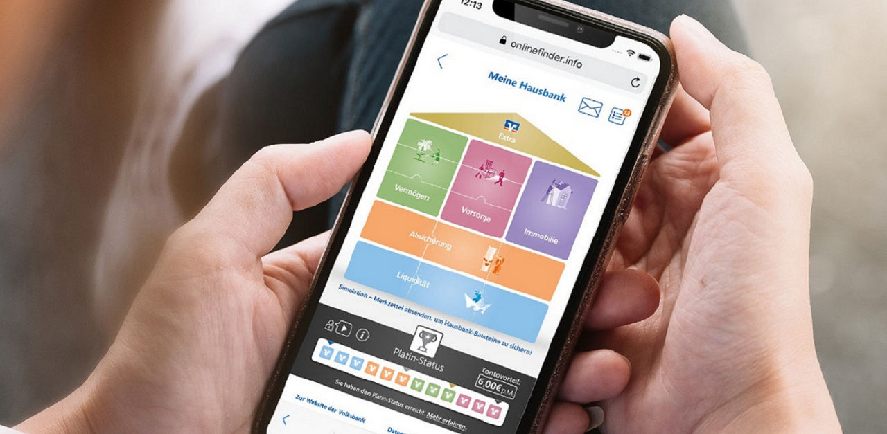 Mann hält Smartphone in Händen, auf dem das Hausbank-Programm der Volksbank angezeigt wird