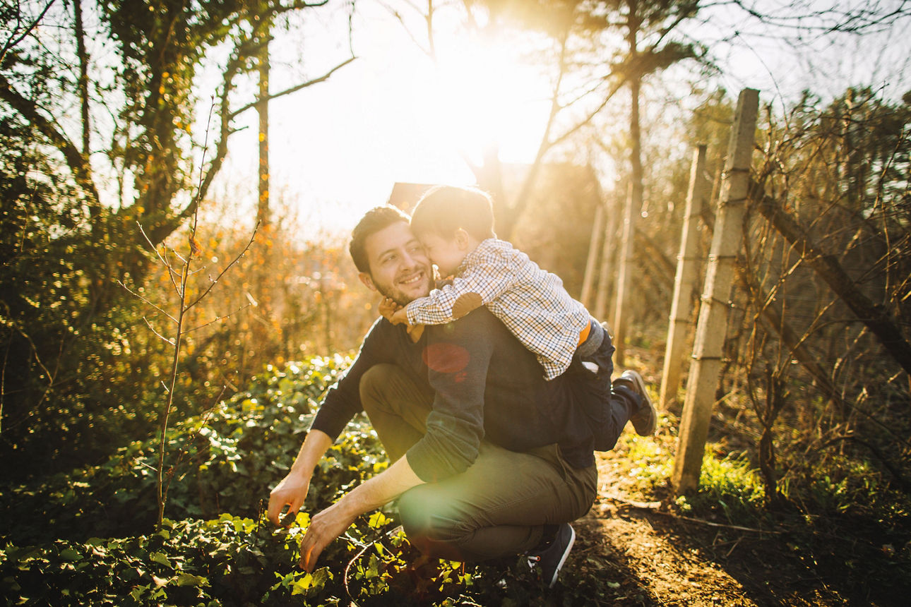 Kind umarmt Vater im Wald