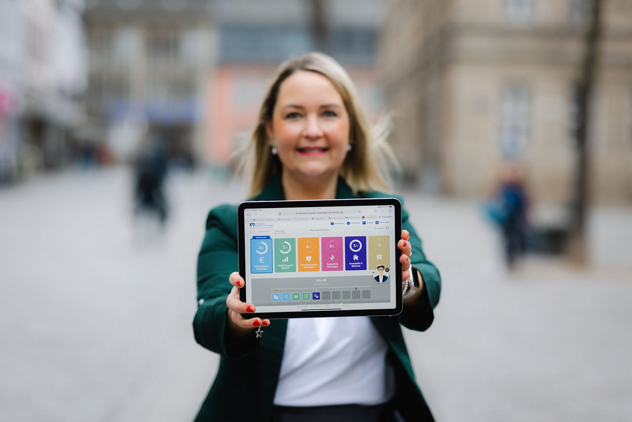 Eine Frau hält ein Tablet in die Kamera