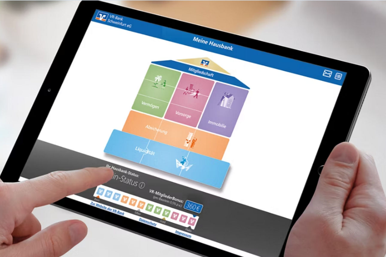Ein Mann mit Laptop auf dem die Grafik des Hausbankprogramms zu sehen ist