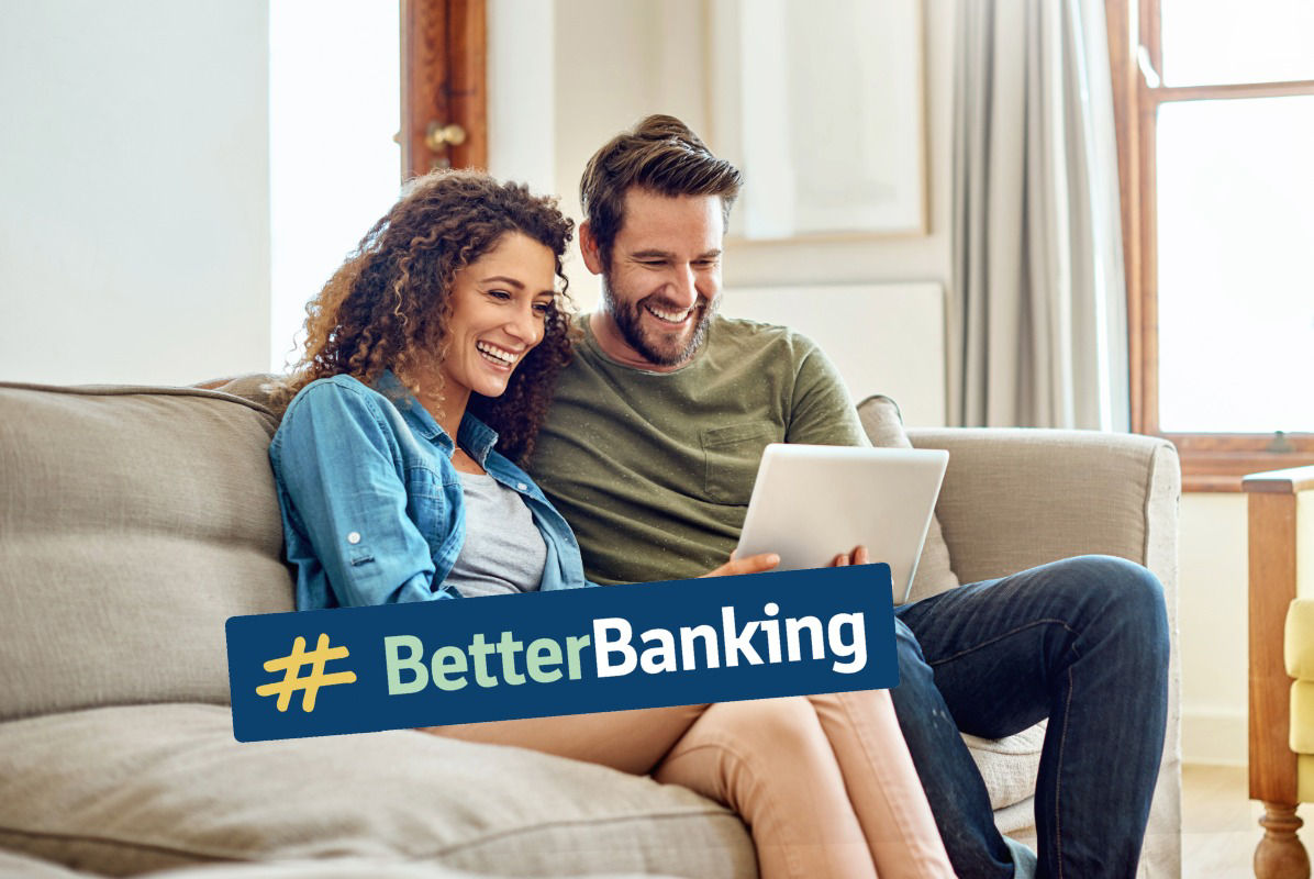 Paar sitzt mit Laptop auf dem Sofa