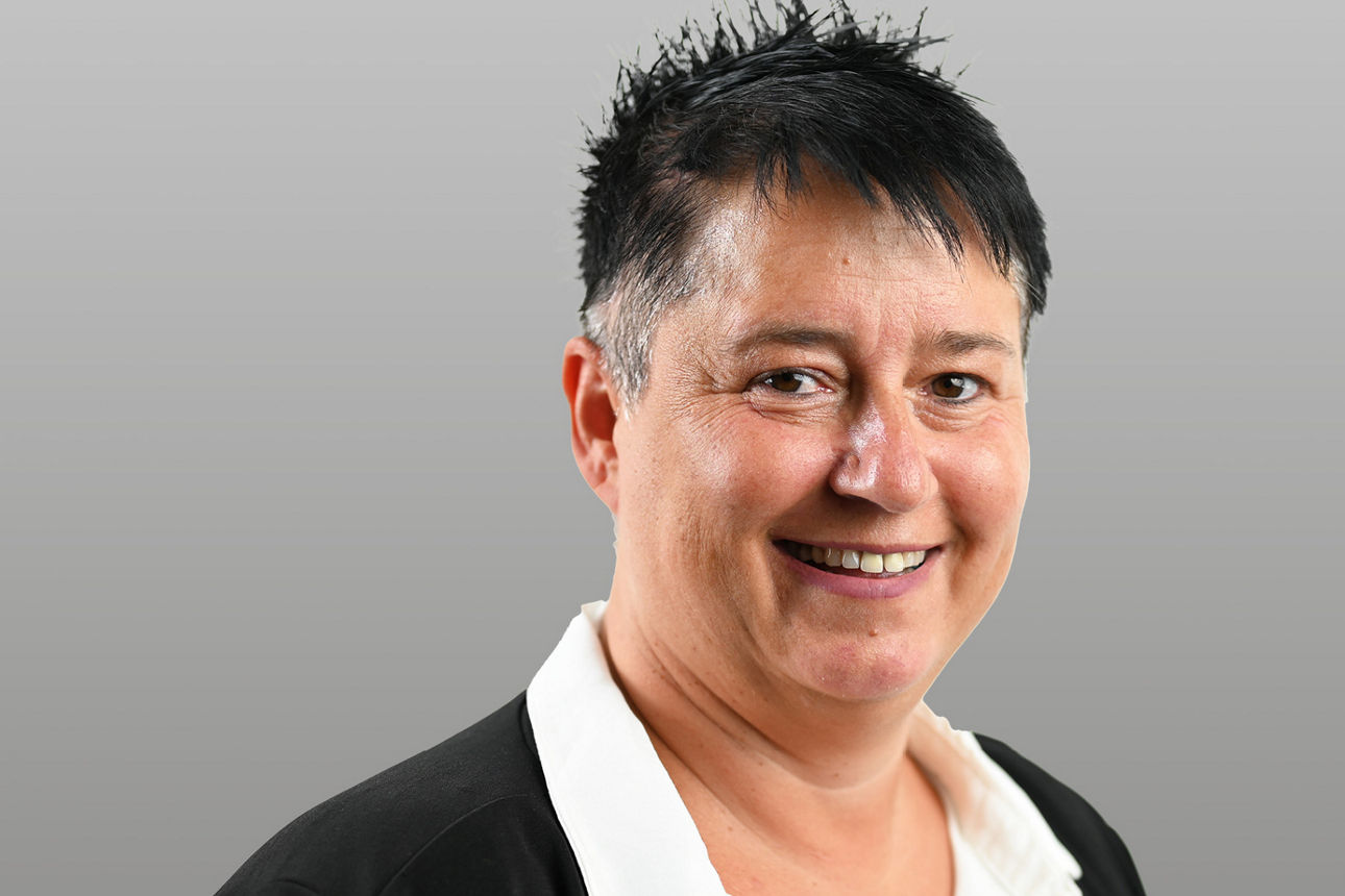 Servicemitarbeiterin Janine Hausmann vor grauen Hintergrund