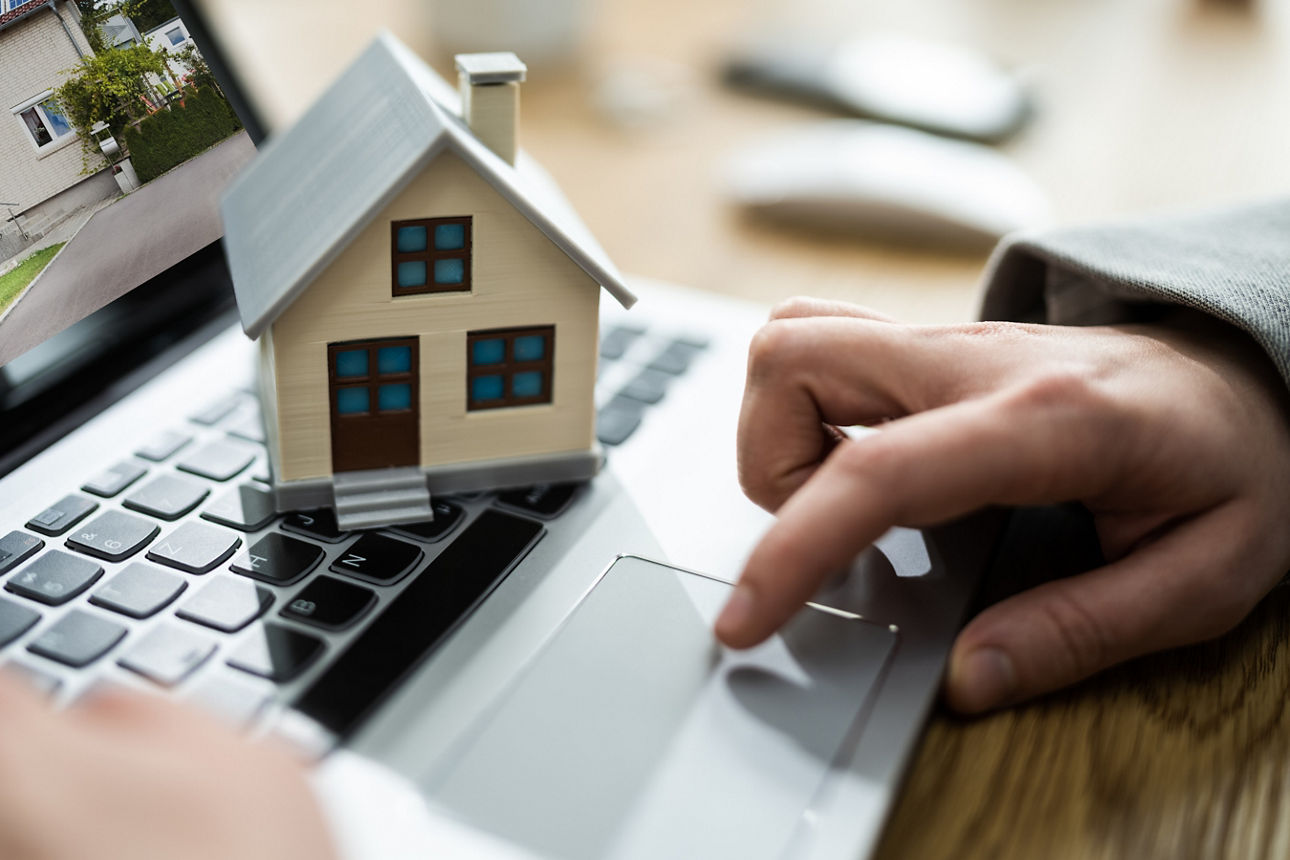 Hausmodell auf der Tastatur eines Laptops.