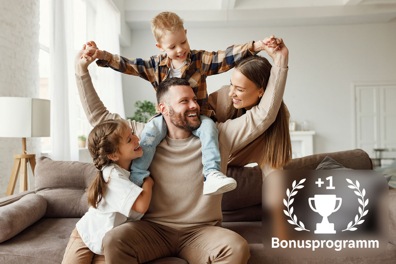 Familie mit zwei Kindern lacht auf dem Sofa