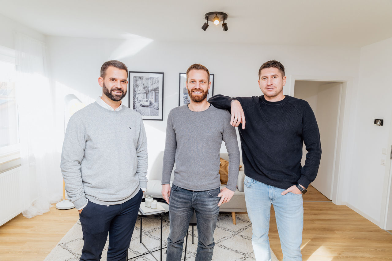 Mehrere Personen stehen in einem hellen Wohnraum einer modernisierten Immobilie der HAVANOLA Immobilien GmbH, der durch hochwertige Materialien, Bodenbelag und zeitgemäße Raumgestaltung geprägt ist.