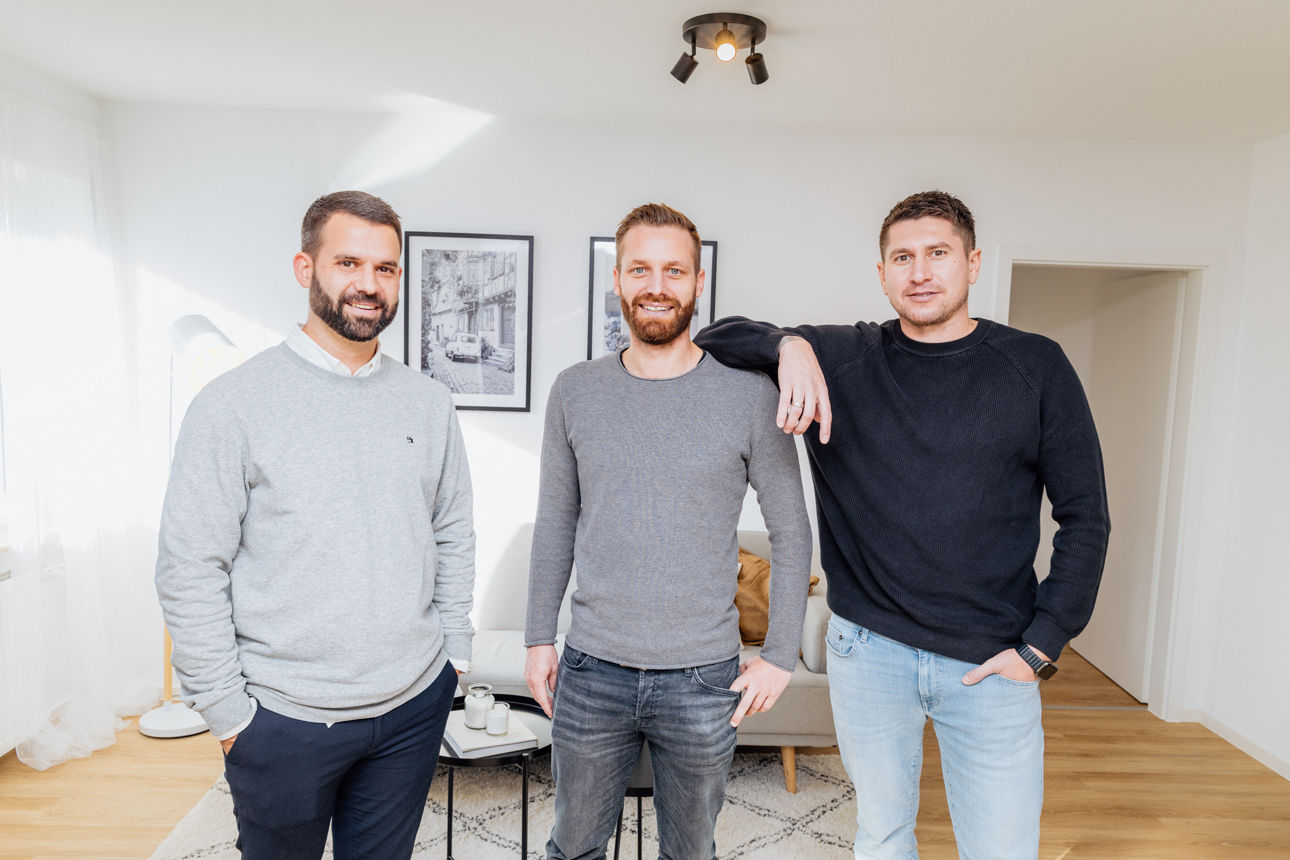 Mehrere Personen stehen in einem hellen Wohnraum einer modernisierten Immobilie der HAVANOLA Immobilien GmbH, der durch hochwertige Materialien, Bodenbelag und zeitgemäße Raumgestaltung geprägt ist.