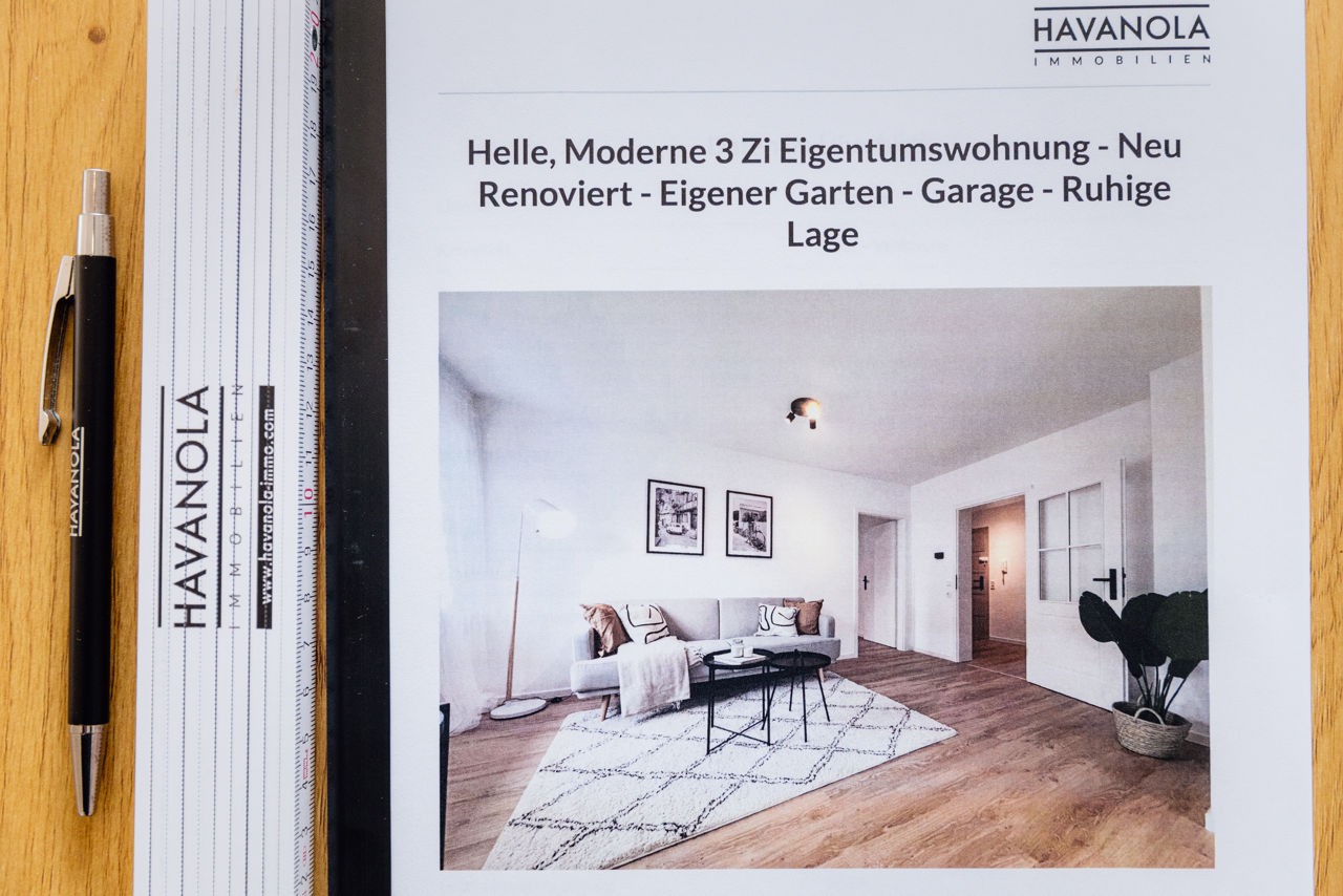 Detailaufnahme eines Immobilienexposés der HAVANOLA Immobilien GmbH mit Beschreibung einer modernisierten Wohnung sowie sichtbarem Markenauftritt.