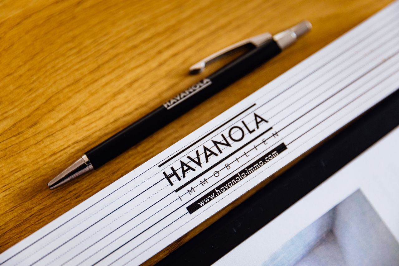 Detailaufnahme eines Schreibgeräts und Maßstabs mit Logo der HAVANOLA Immobilien GmbH als Symbol für Planung, Projektentwicklung und Präzision.