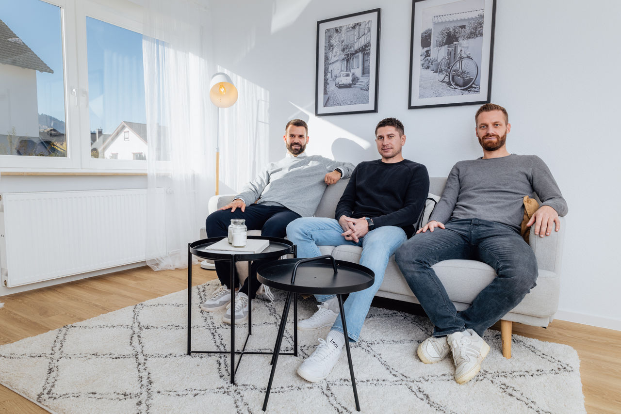 Mehrere Personen sitzen in einem Wohnbereich einer modernisierten Immobilie der HAVANOLA Immobilien GmbH, umgeben von heller Einrichtung und zeitgemäßer Raumgestaltung.