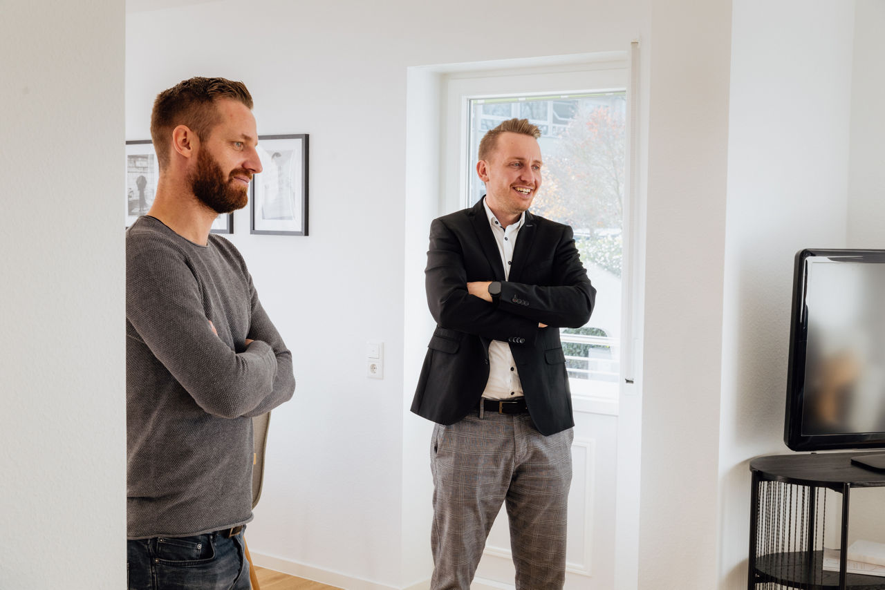 Zwei Personen stehen in einem Wohnraum einer von der HAVANOLA Immobilien GmbH entwickelten Immobilie und begutachten den fertigen Innenbereich.