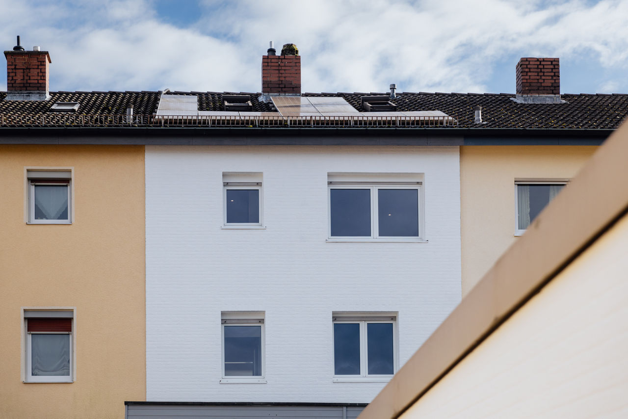 Außenansicht eines renovierten Mehrfamilienhauses der HAVANOLA Immobilien GmbH mit neuer Fassadengestaltung und modernisierten Fenstern.