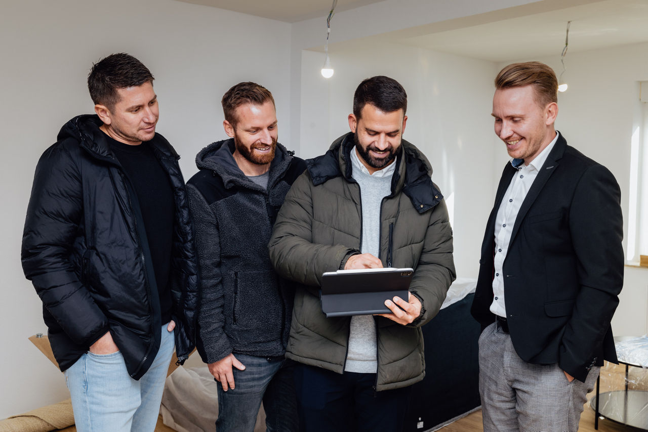 Mehrere Personen stehen in einem unfertig ausgebauten Innenraum einer Immobilie der HAVANOLA Immobilien GmbH und besprechen den Bau‑ und Ausbaufortschritt.