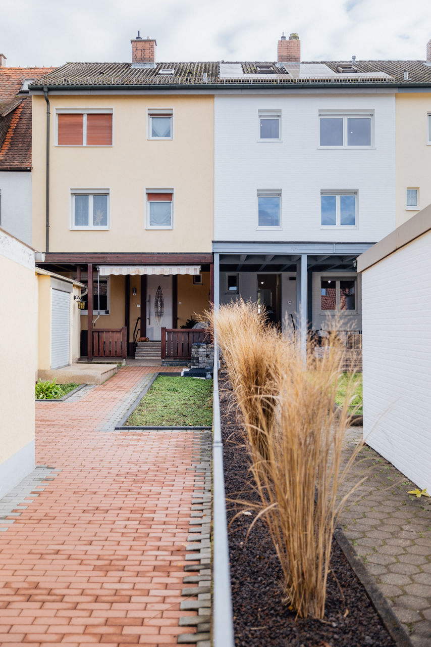 Außenaufnahme eines modernisierten Wohngebäudes der HAVANOLA Immobilien GmbH mit gestaltetem Eingangs‑ und Außenbereich zwischen Wohnhäusern.