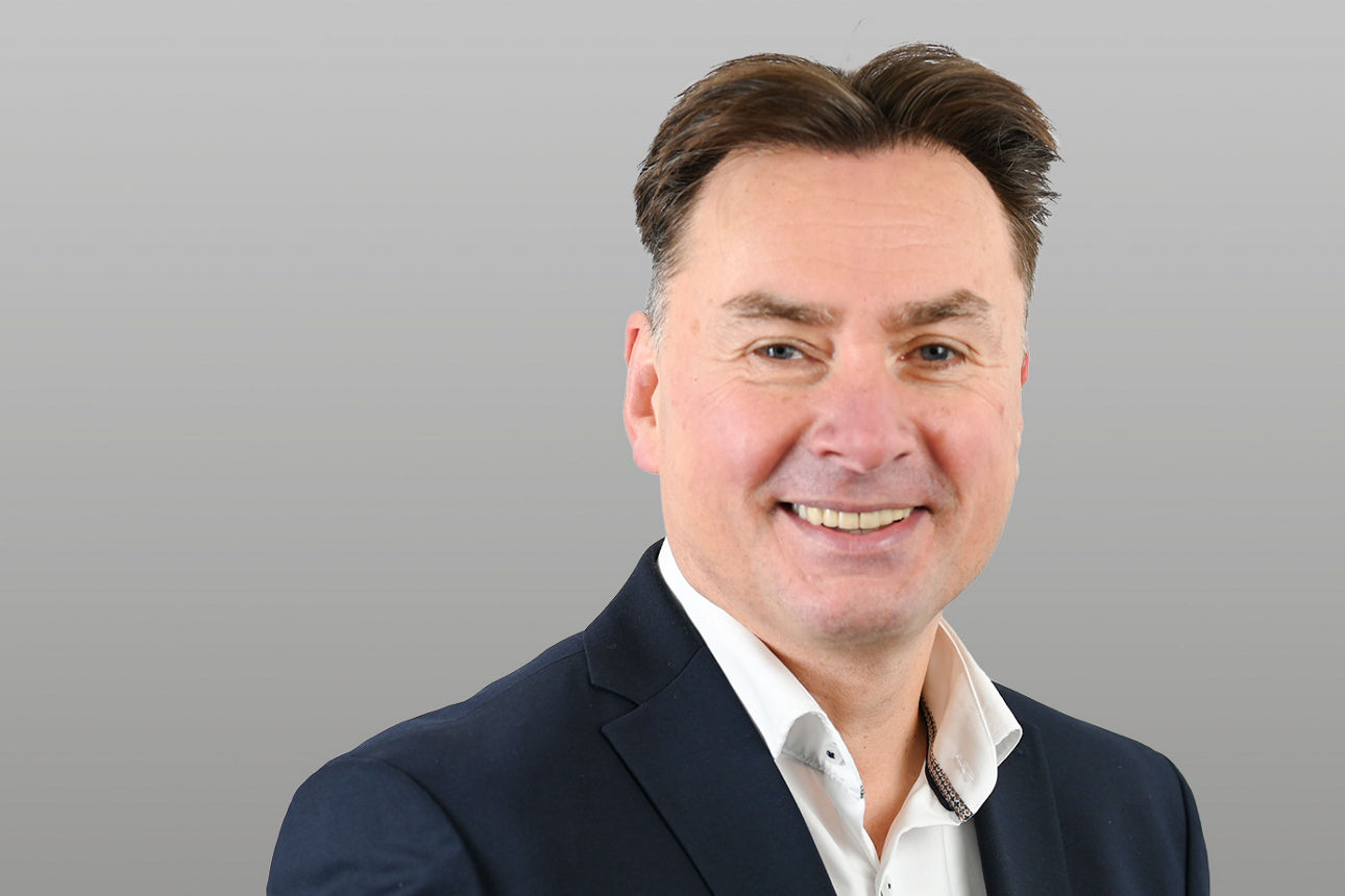 Carsten Heßler, Firmenkundenberater, vor grauem Hintergrund