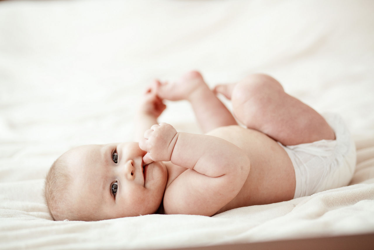 Baby liegt auf Decke