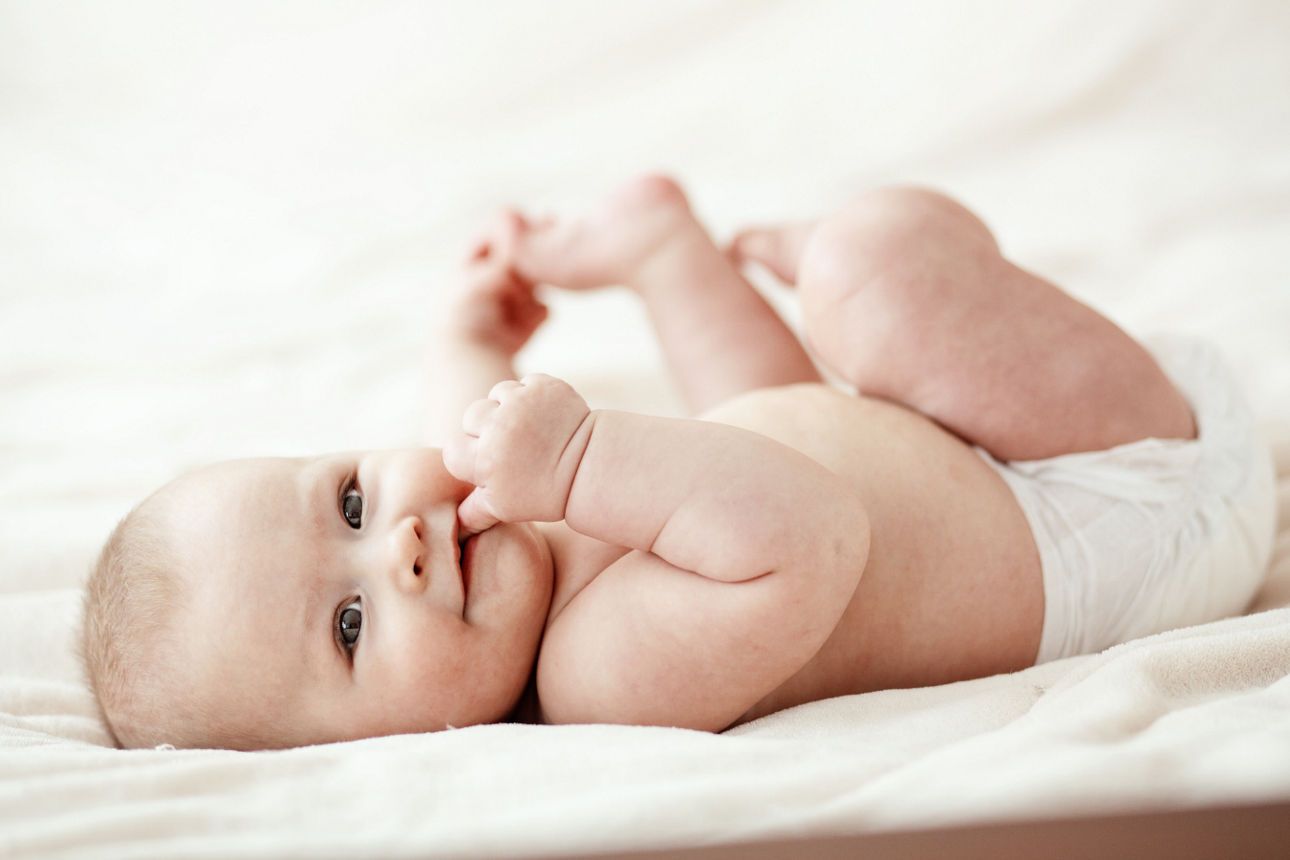 Baby liegt auf Decke