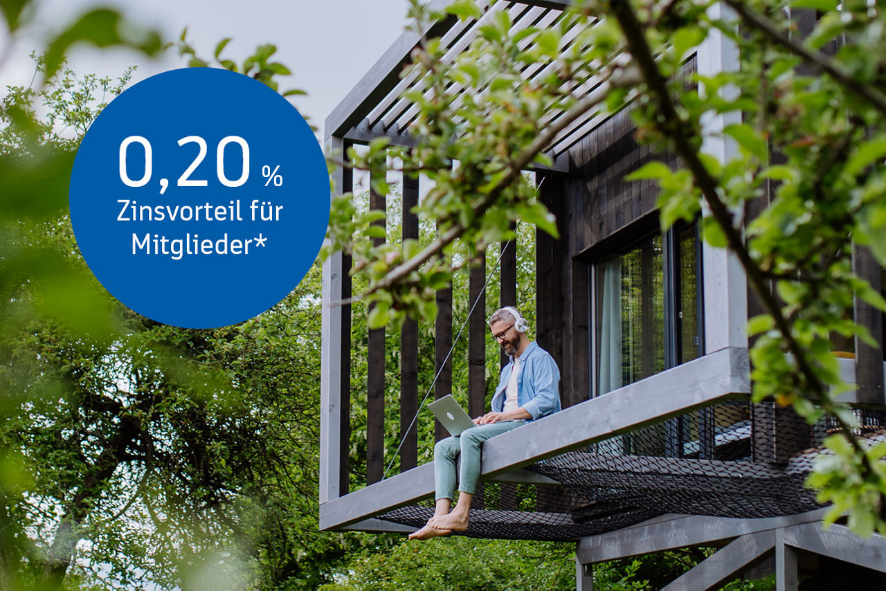 Man mit einem Laptop und Kopfhörern in einem Baumhaus. Buttons mit der Aufschrift 0,20% Zinsvorteil für Mitglieder.
