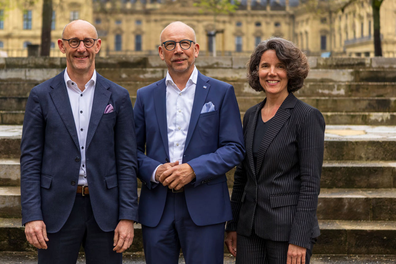 Claus Reder, Joachim Erhard und Dr. Pia Weinkamm, im Hintergrund die Residenz Würzburg