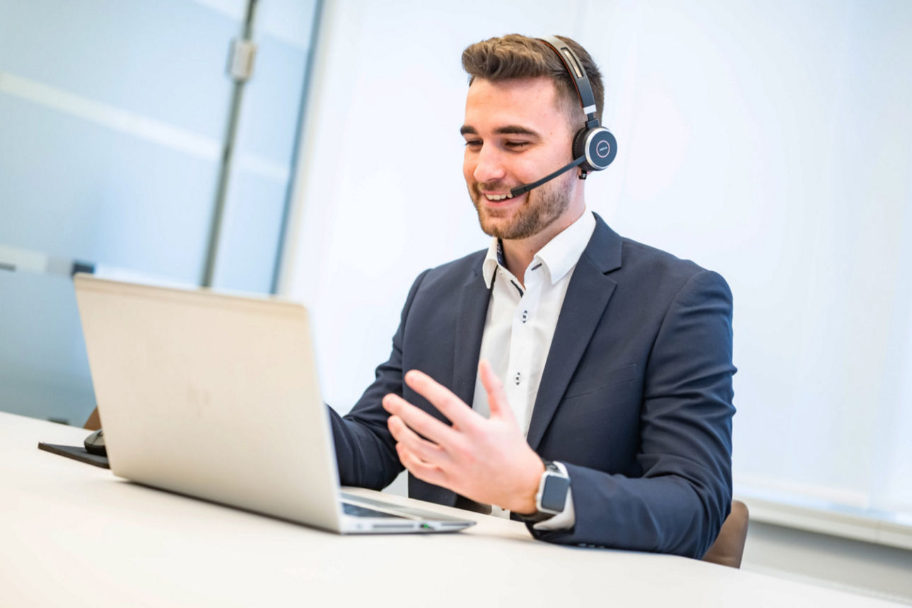Student sitzt mit Headset vor seinem Laptop