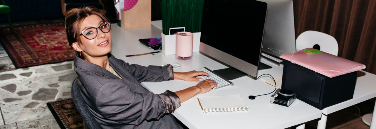 Eine elegant gekleidete junge Frau vor einem Computer