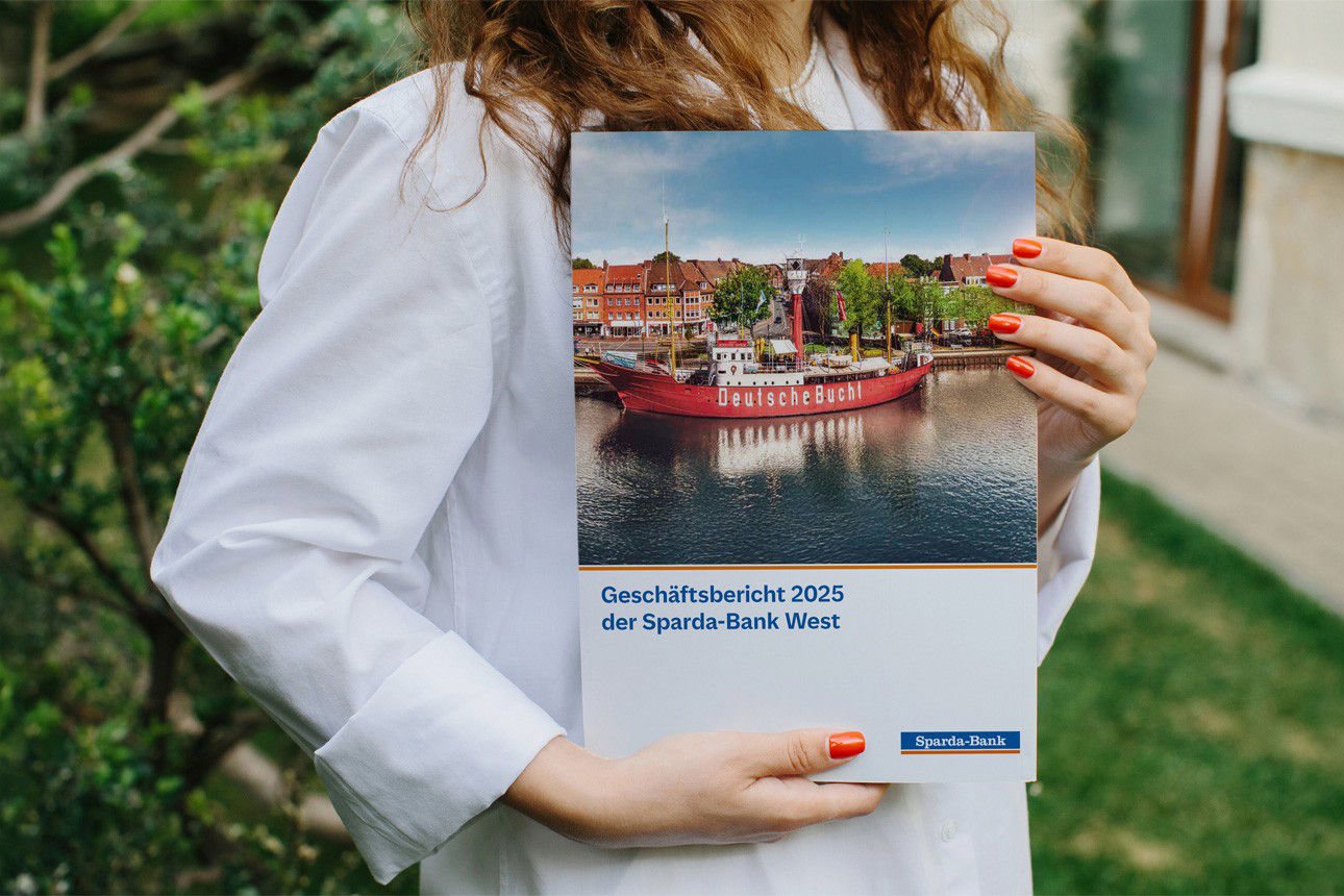 Frau hält Geschäftsbericht der Sparda-Bank West 2025 in der Hand