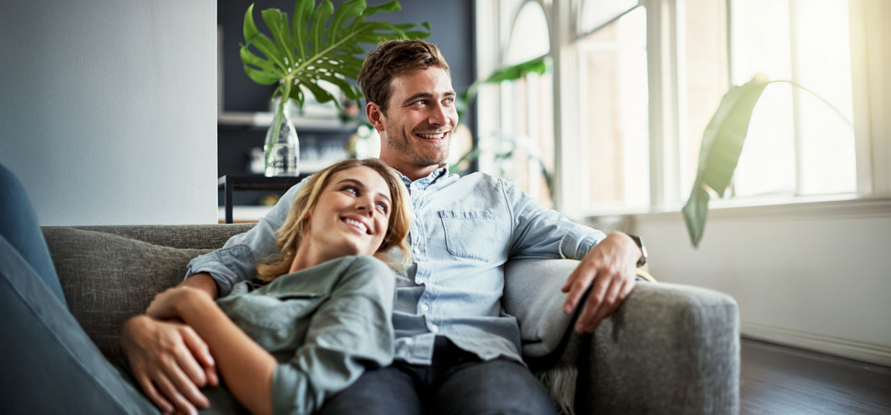 Junges Paar liegt zusammen auf dem Sofa