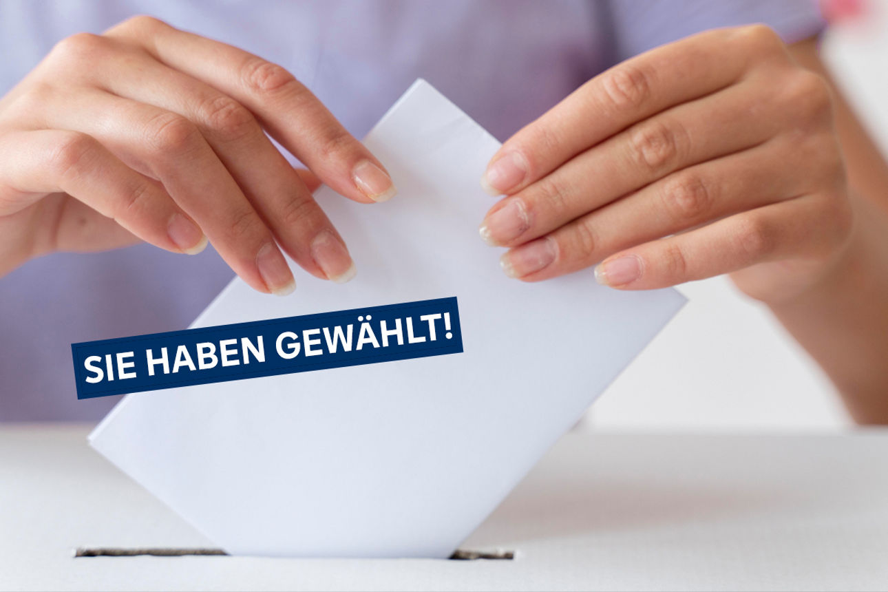 Person wirft Stimmzettel ein, Aufschrift "Sie habe Gewählt"