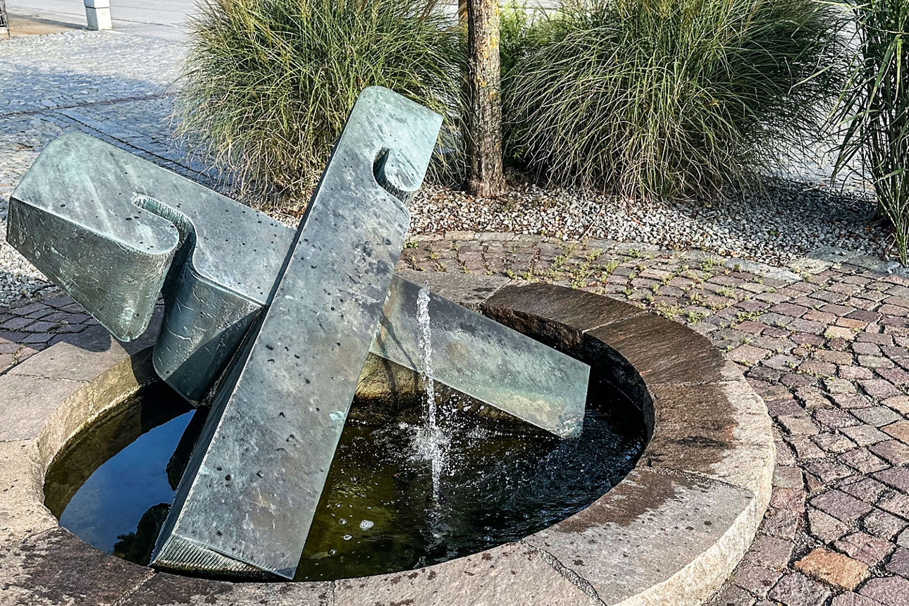 Ein Brunnen mit dem Raiffeisen-Symbol.