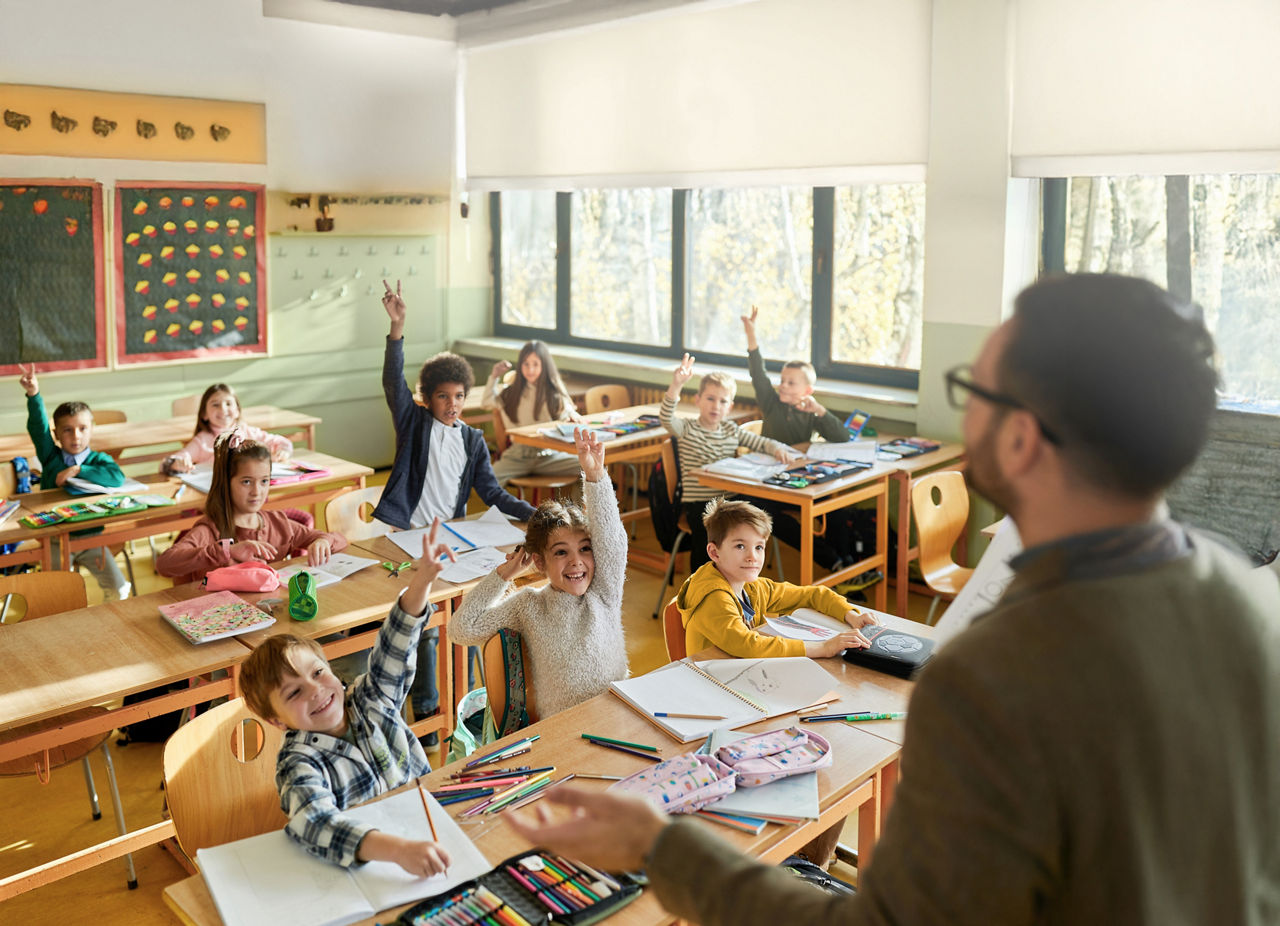 Lehrer mit Kindern in einem Klassenzimmer einer Schule.