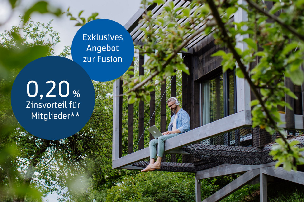 Man mit einem Laptop und kopfhörern in einem Baumhaus. Zwei Buttons mit der Aufschrift 0,20% Zinsvorteil für Mitglieder.