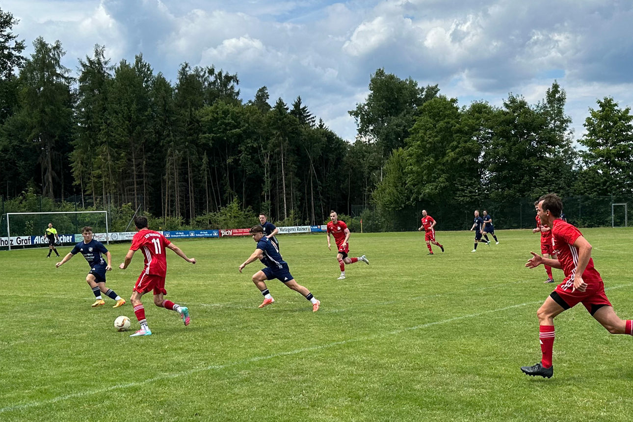 Fußballspieler aus unterschiedlichen Teams laufen auf dem Spielfeld.