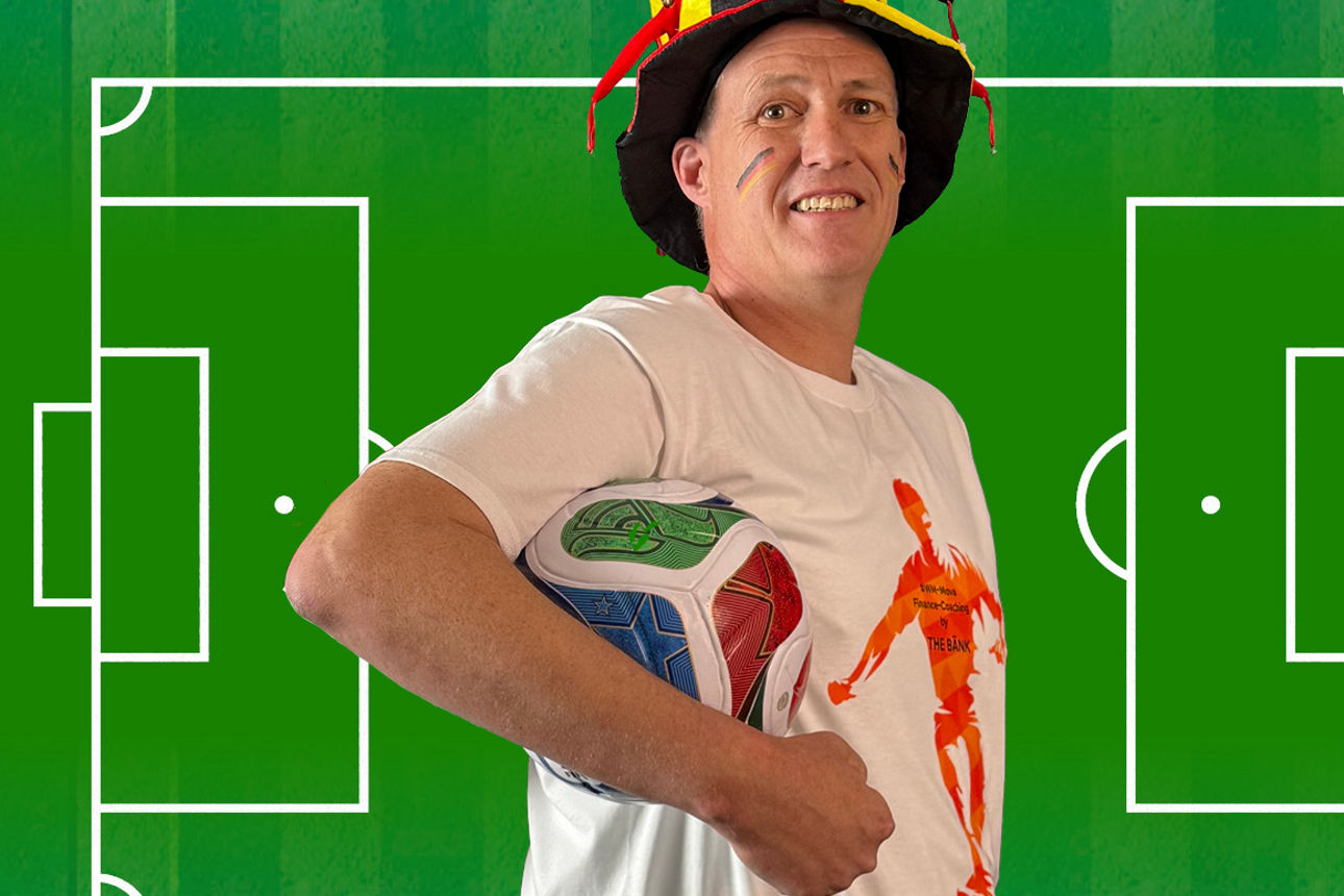 Sie sehen einen Mitarbeiter, der einen Fußball unter seinem Arm hält.