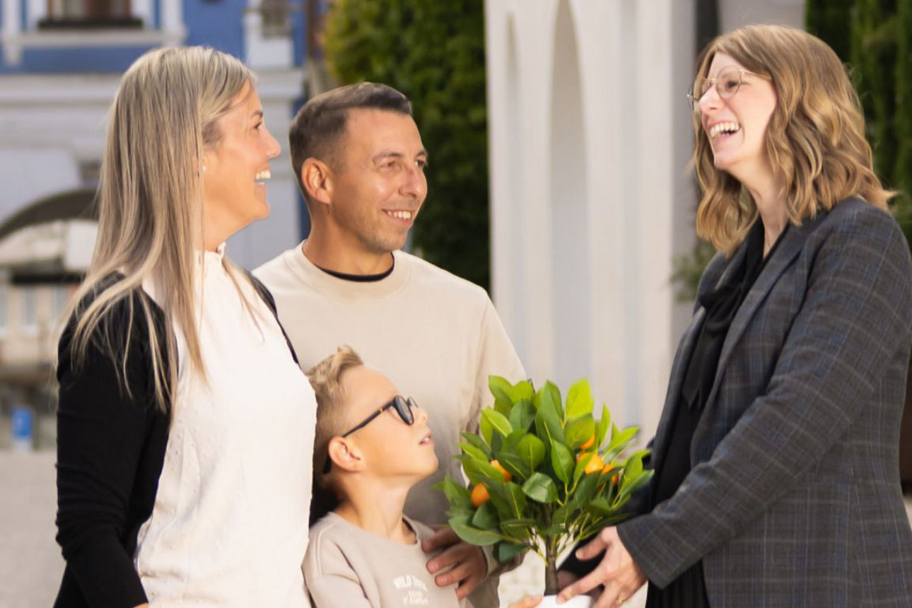 Familie bekommt als Symbol für die Heimatpolice ein Bäumchen geschenkt
