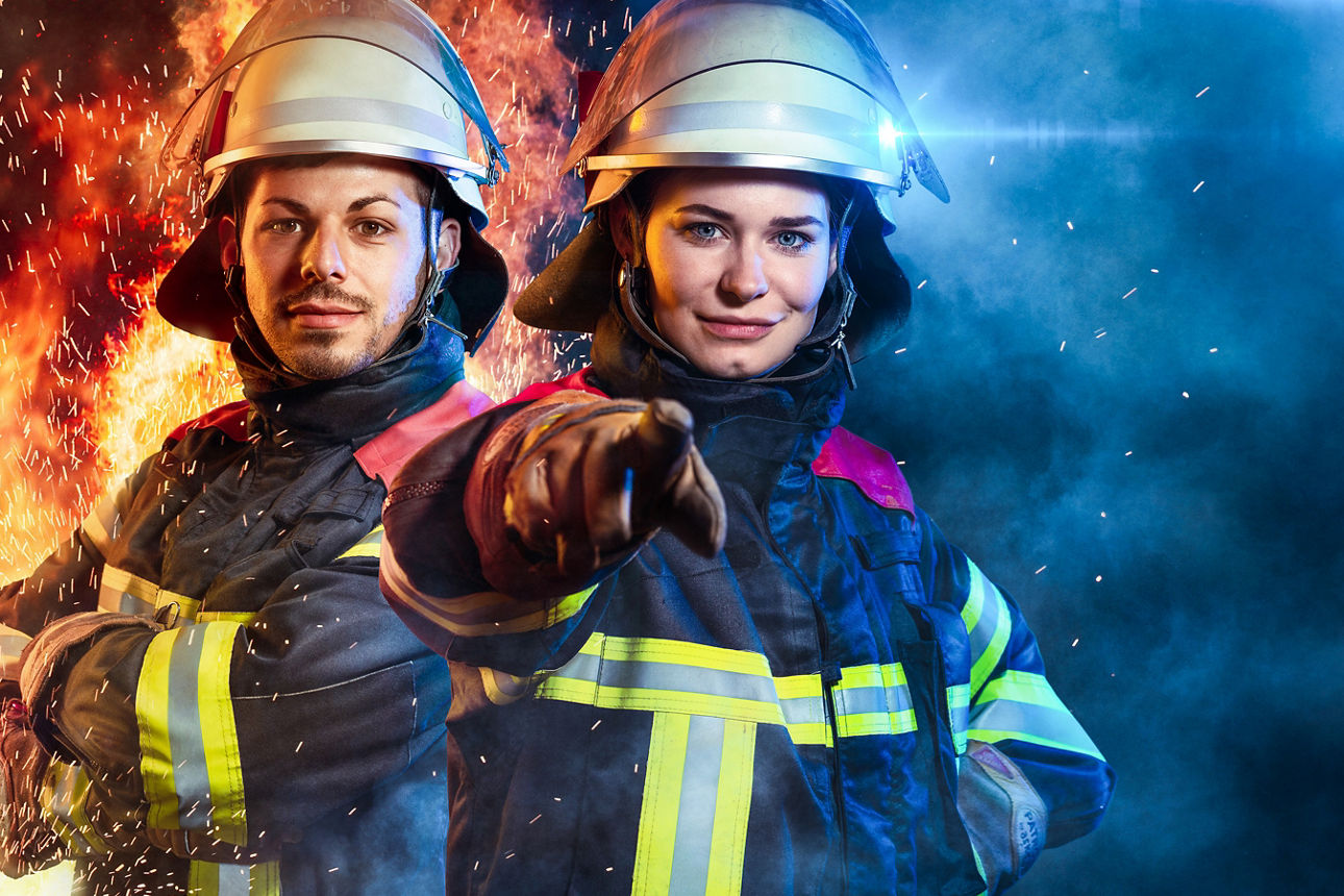 Rettungskräfte Frau und Mann in Uniform mit Helm und Schutzhandschuhen