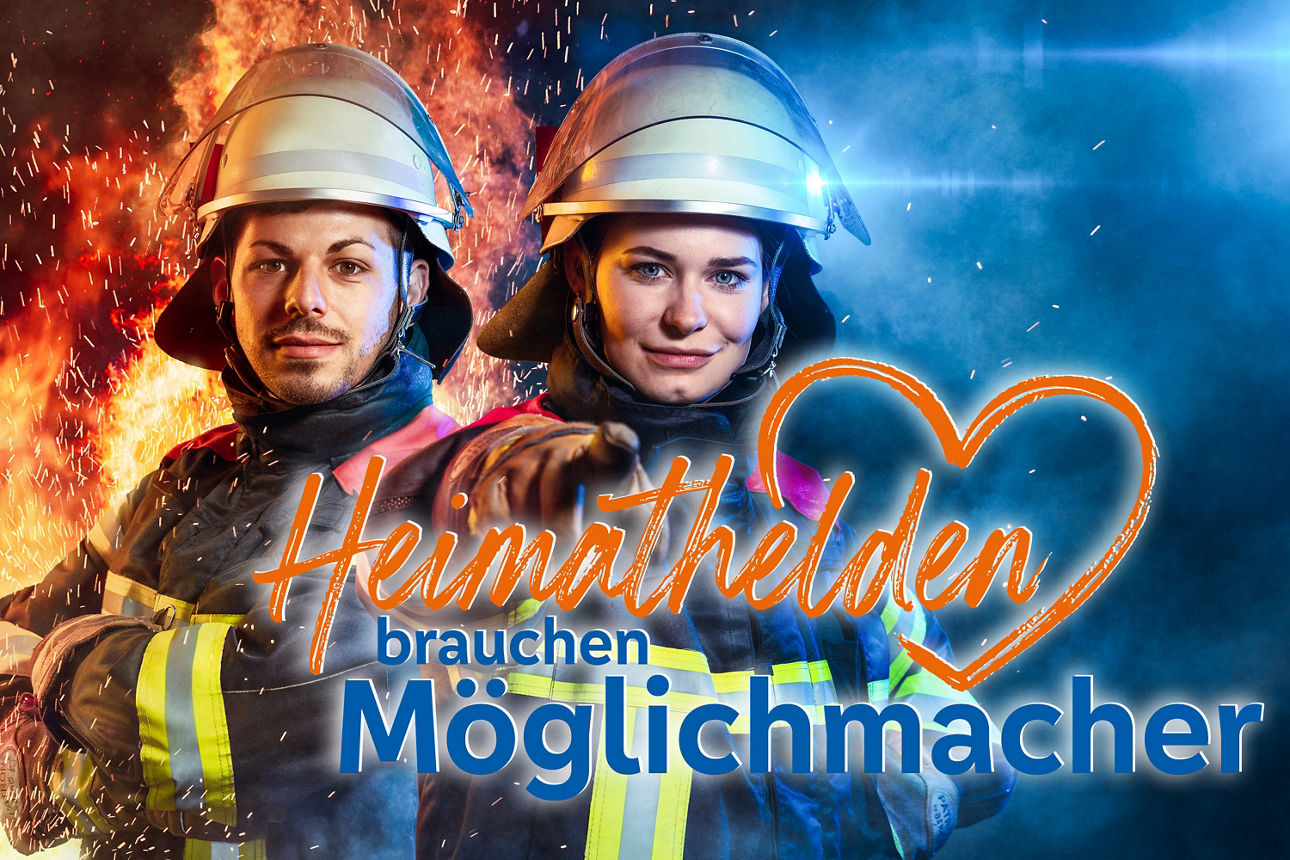 Eine Feuerwehrfrau mit dem Finger in die Kamera zeigend und eine Feuermann der mit verschränkten Armen vor Feuerflammen steht