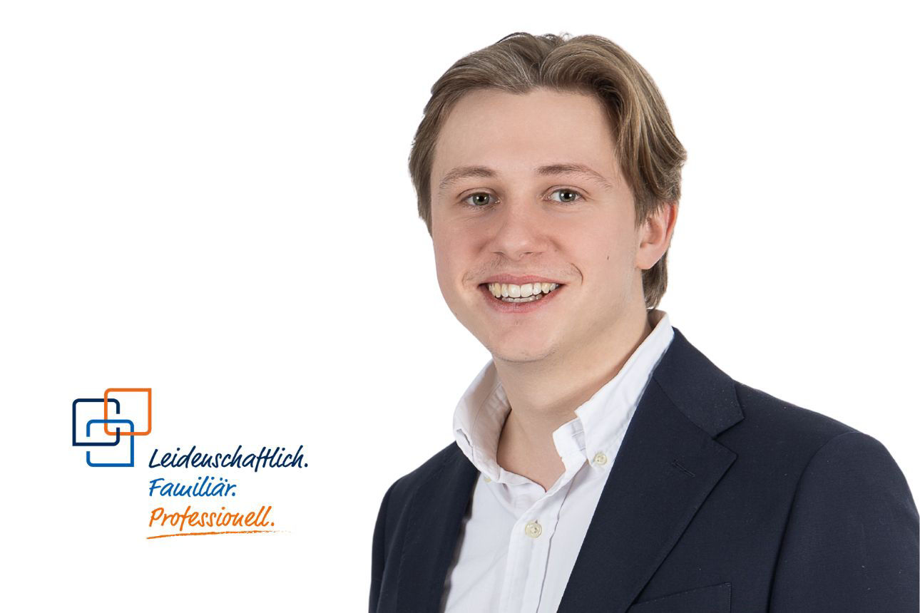 Mann in Blazer, lächelnd, vor weißen Hintergrund