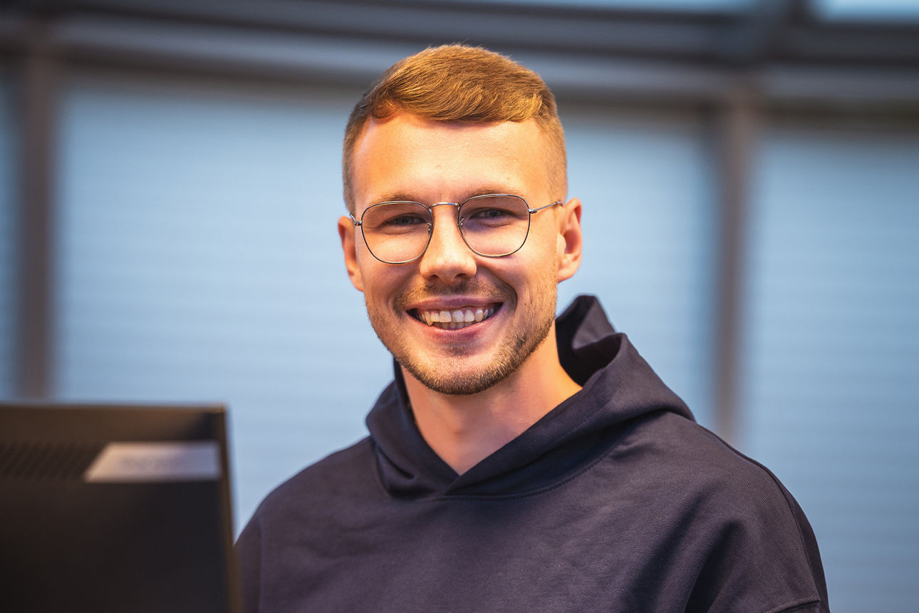 Auszubildender steht am Schalter