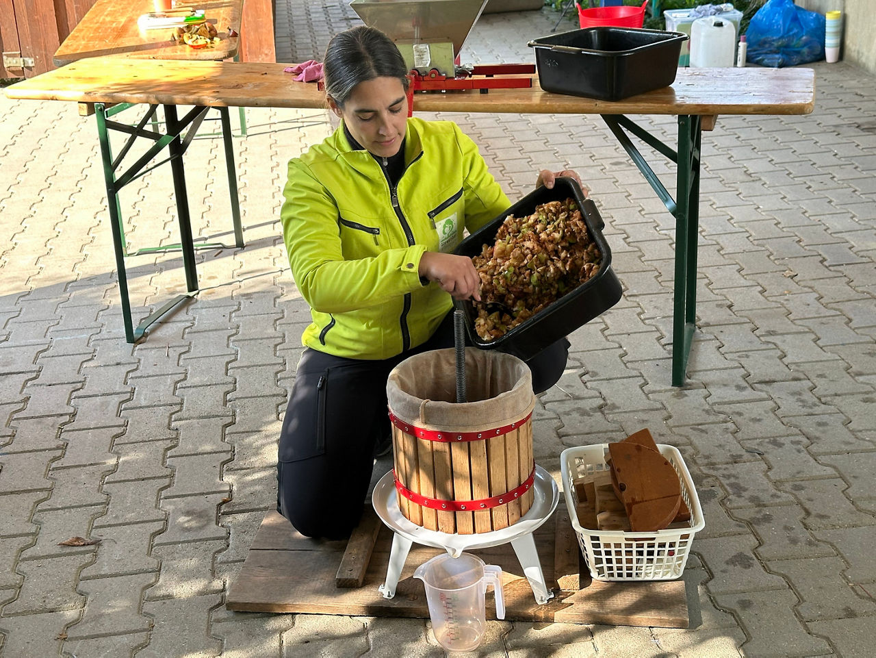 Umweltpädagogin Katrin Dickgießer-Weiß beim Pressen von Äpfeln mit einer Saftpresse.