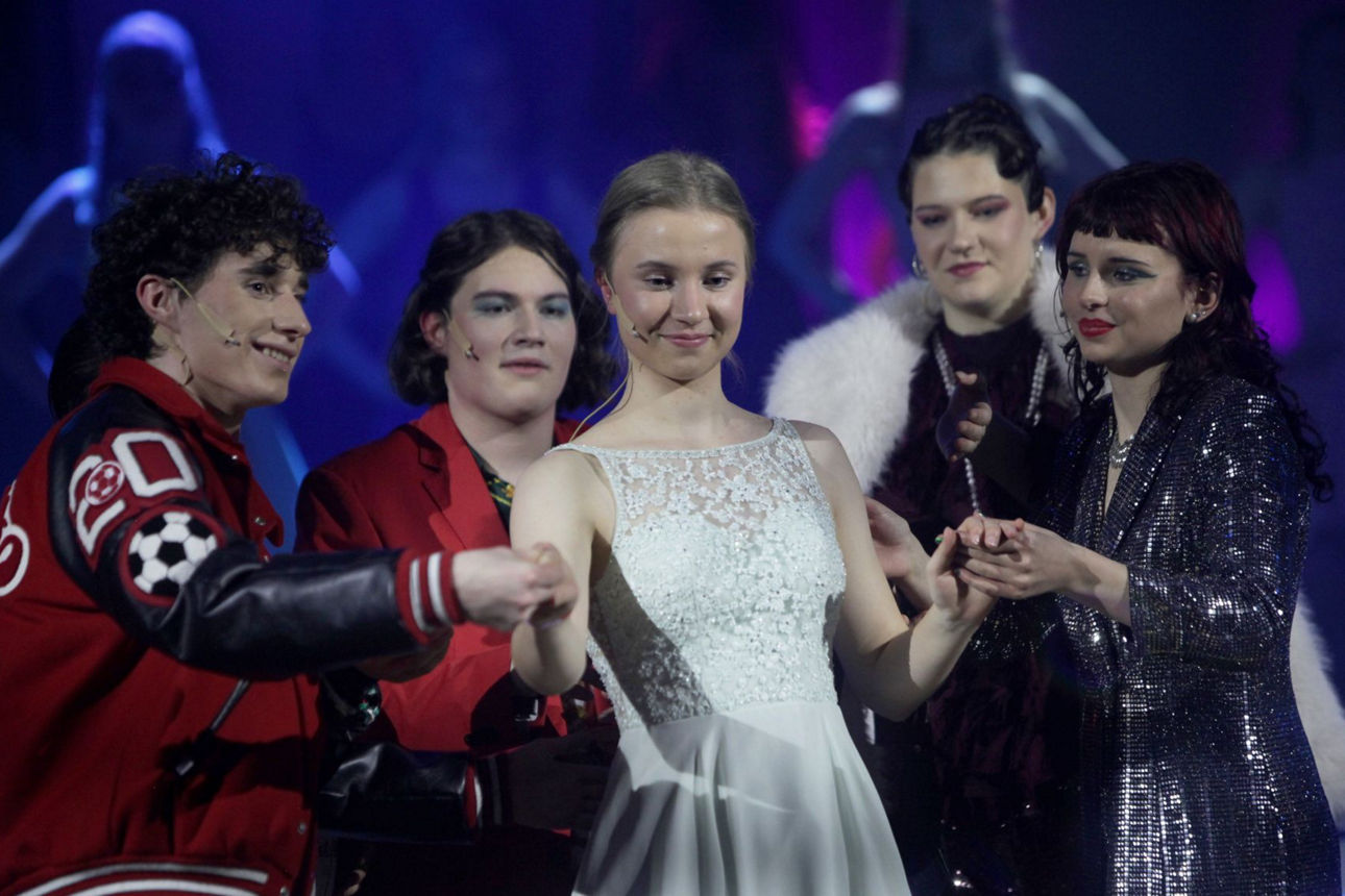 Glamouröse Musical-Stars geleiten die festlich gekleidete Emma zu ihrem Ball