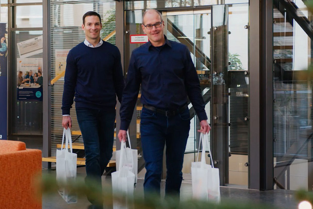 Die Vorstände der Volksbank mit Tüten in den Händen