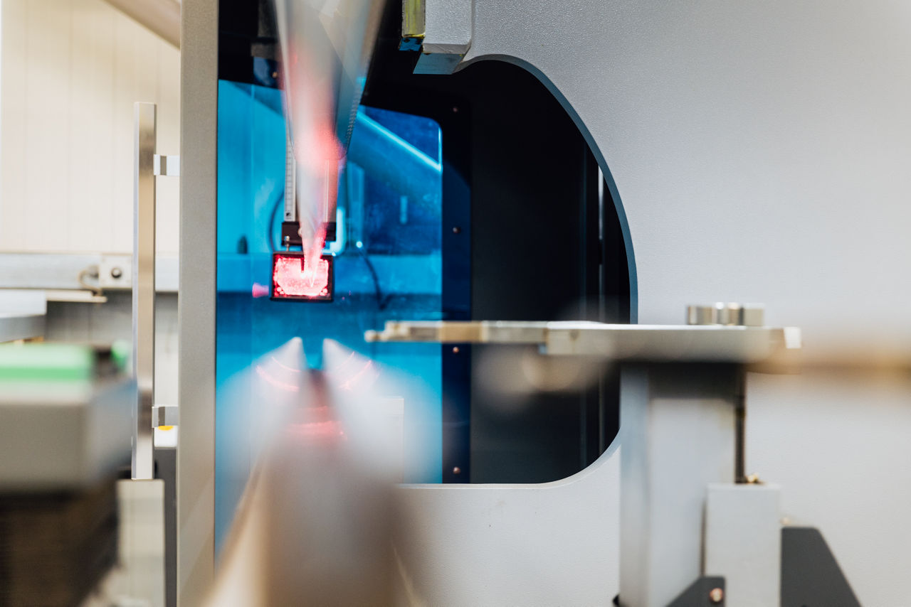 Detailansicht des Werkzeugbereichs einer CNC‑Abkantpresse bei der „Herrlich GmbH“ während des aktiven Bearbeitungsprozesses. Sichtbar sind das eingesetzte Werkzeug sowie das bearbeitete Metallbauteil im laufenden Abkantvorgang innerhalb der Metallverarbeitung