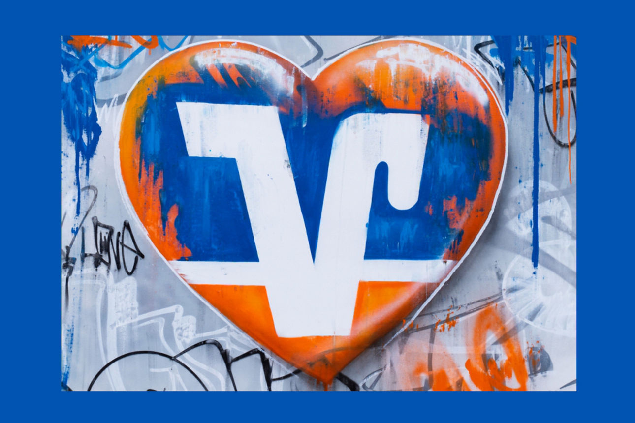 Ein Volksbank symbol in einem HErz in den Farben blau und Orange.