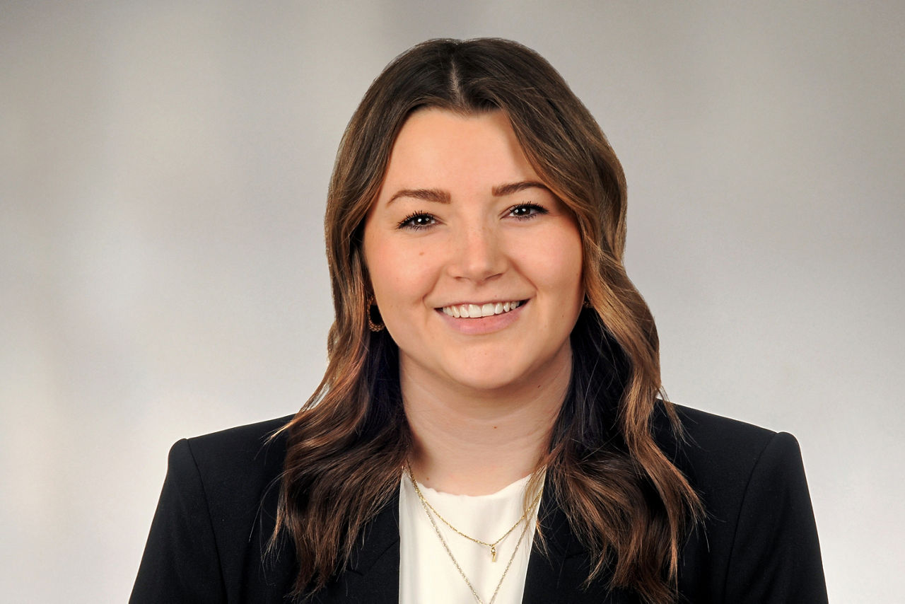 Jocelyn Heymach hat braune lange Haare und trägt ein Businessoutfit und eine goldene Kette