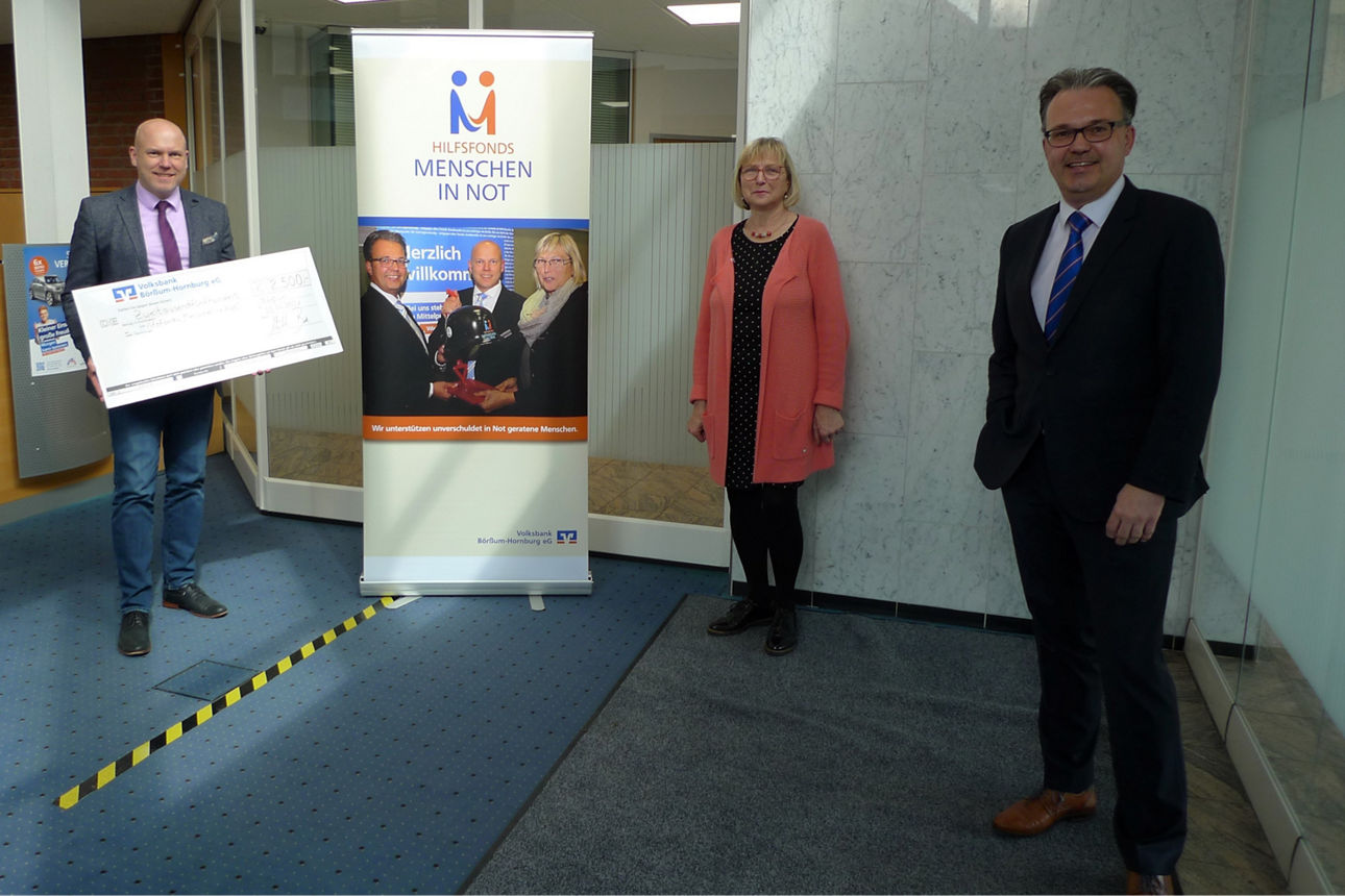 drei Menschen die vor eimem Flipchart stehen 