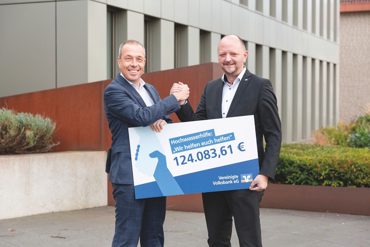 Zwei Personen mit einem Spendenscheck in der Hand