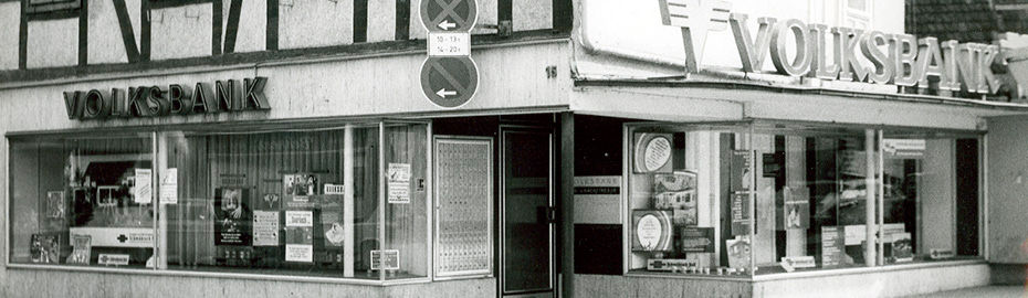 Schwarz-Weiß-Foto eines Volksbank-Gebäudes in Höxter mit großem Schriftzug ‚VOLKSBANK‘ über dem Eingang und Schaufenstern mit