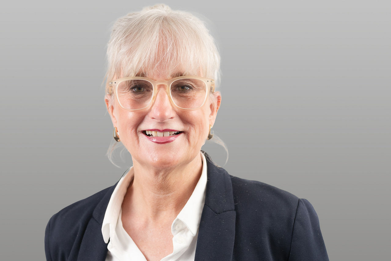 Servicemitarbeiterin Stefanie Hofer vor grauen Hintergrund