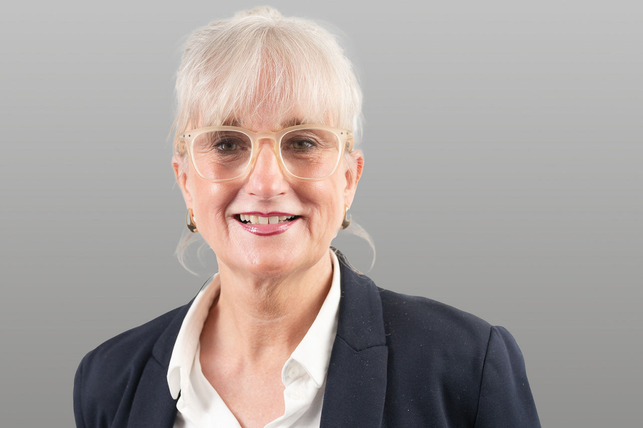 Servicemitarbeiterin Stefanie Hofer vor grauen Hintergrund
