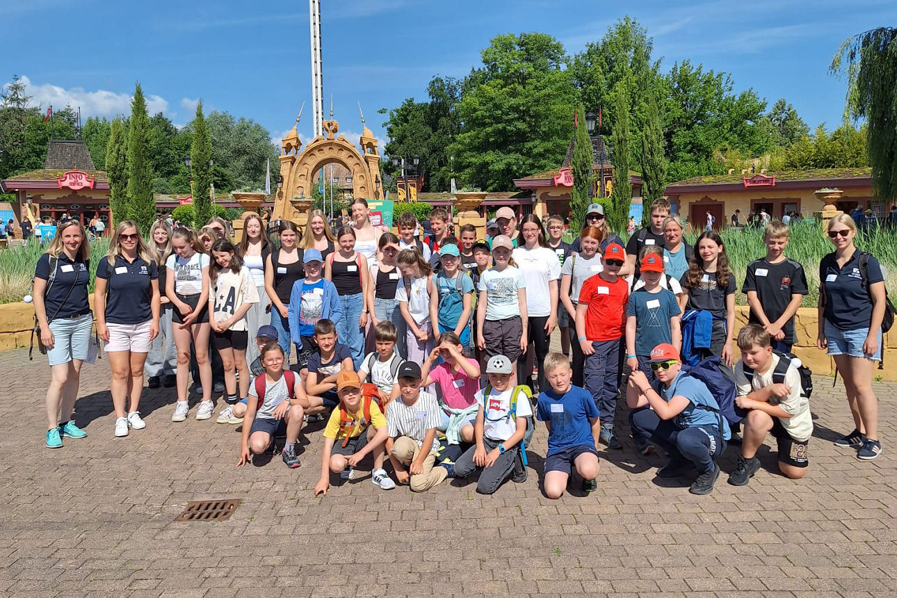 Gruppenfoto vor dem Eingang des Holiday Parks: Kinder und Betreuer der VR-Bank Main-Rhön beim MeinClub-Ausflug